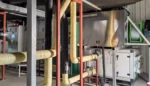 Real installation photo of Fengxing FXE low temp regeneration rotary dehumidifier, complete thermal insulation pipeline layout in industrial production workshop