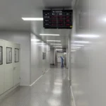 Internal passage inside clean & dry dehumidification room, overhead multi-area digital monitor panel displays real-time dew point (-51.6℃ ~ -61.3℃), temperature and pressure difference data for coating, mixing and material storage zones, stable ultra-low humidity environment for lithium ion, solid state and sodium ion battery production lines, full turnkey OEM dry room EPC project matched with FXD low dew point desiccant rotor dehumidifier